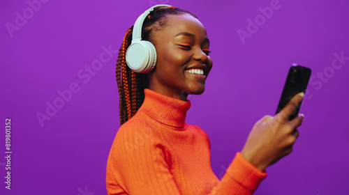 Happy gen z girl listening to music with headphones and browsing on smartphone