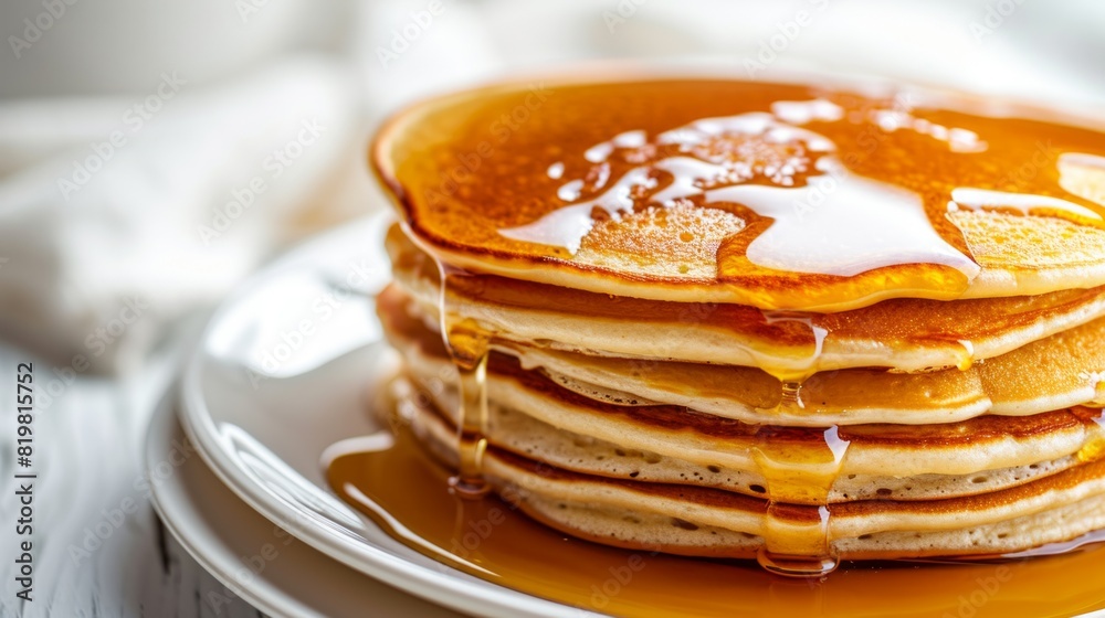 Pancakes with butter and honey syrup on the white plate isolated on a white background Pancakes with butter and honey syrup on the white plate isolated on a white background