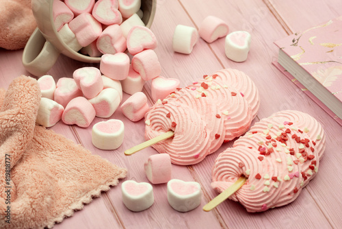 Pink dessert. Sweet marshmallow hearts and two pink soufflé cakes on a wooden table. photo