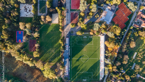 Soccer field with goal and penalty area from above. Overhead view of the penalty area of a football pitch with synthetic grass. No people. Sunset background texture 