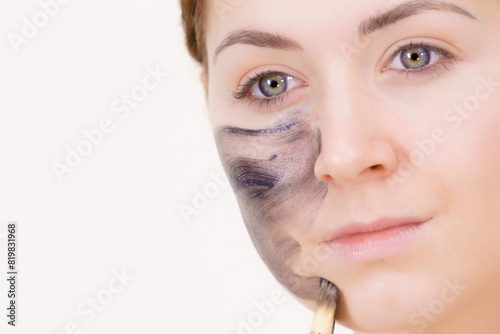 Woman being apply black carbo mask to face photo