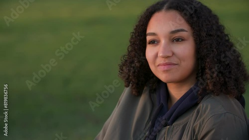 Beautiful mixed race African American girl biracial teenager young woman outside smiling outside in a park