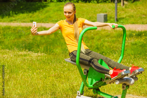 Girl doing exercises outdoor, taking selfie
