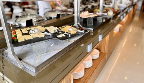 A buffet table with a variety of dishes, including fast food, various cheeses and savory snacks