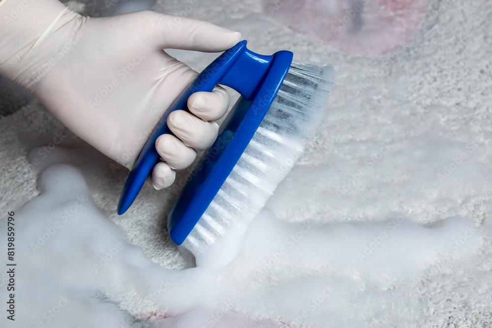 Blue brush on the floor with hand in rubber glove. Cleaning. Blue brush on the floor with hand in rubber glove. Cleaning.