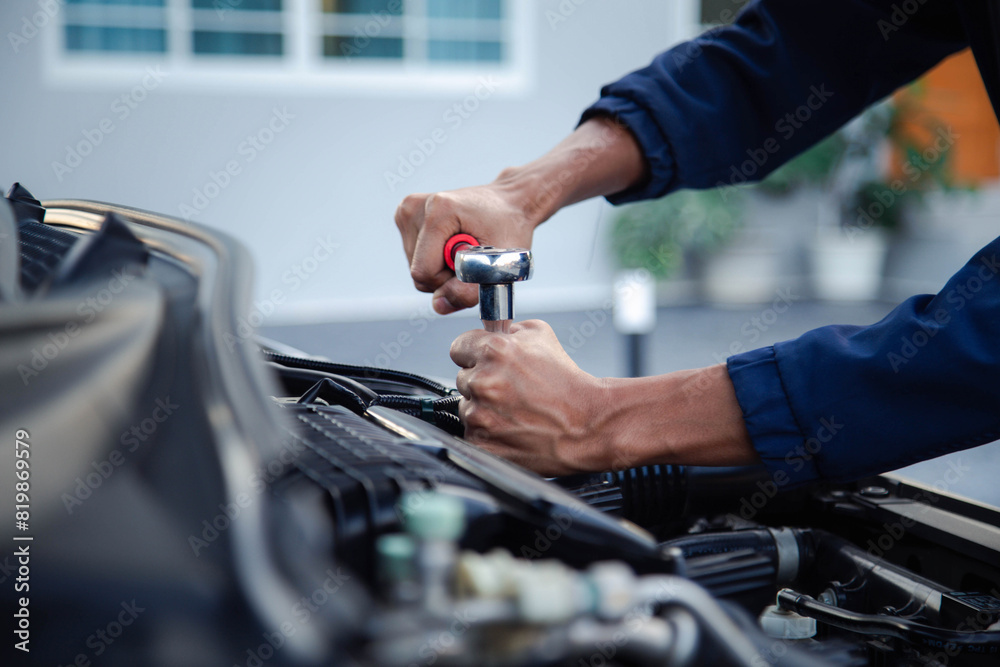 Professional mechanic working on the engine , repairing a car engine automotive workshop with a wrench, car service and maintenance,Repair service.