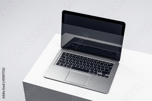 Sophisticated laptop on a white podium with a dark screen, set in a minimalist environment, ideal for tech presentations. 3D Render © Who is Danny