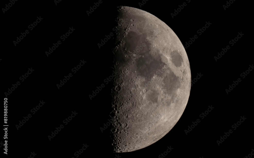 Księżyc w pierwszej kwadrze z widocznymi morzami i kraterami - Moon