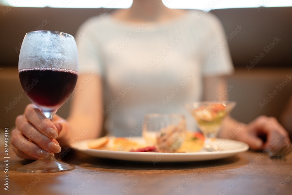 ワインを飲みながら食事をする女性