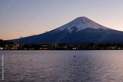 A distant view on Mt Fuji in Japan on a clear The top parts of the volcano are covered with a layer of snow.