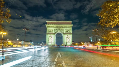 4K Timelapse of traffic at Arc de Triomph at night. This historical monument overlooks the avenue des champs élysées in the heart of Paris, French capital. photo