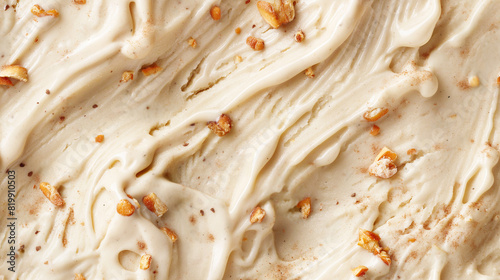 top view of carrot cake ice cream surface, a closeup of the carrot cake ice cream texture, highlighting its creamy base with pieces of carrot cake and a hint of cinnamon