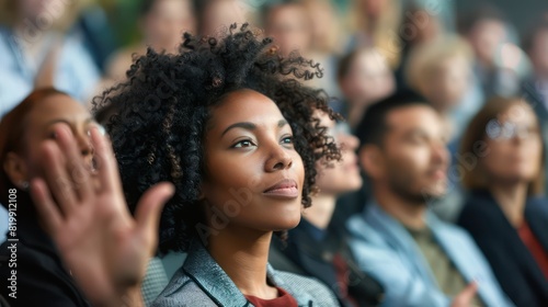 A female entrepreneur stands out in the audience, her hand raised high as she prepares to contribute her perspective during a conference.  photo