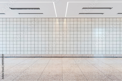 Empty subway station with a clean tiled wall and floor, modern ceiling lights, concept of public transportation space. 3D Rendering © Who is Danny