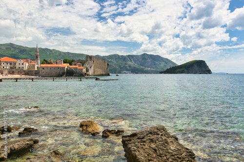 Budva, Montenegro - May 04, 2024 : The Old Town Fortress in Budva. A stone wall on the shore of the Adriatic Sea in Montenegro. Horizontal. On a hot, sunny, spring afternoon. photo