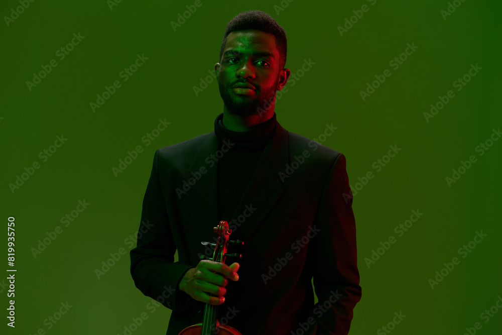 Elegant man in suit playing violin in front of green screen on black background Elegant man in suit playing violin in front of green screen on black background
