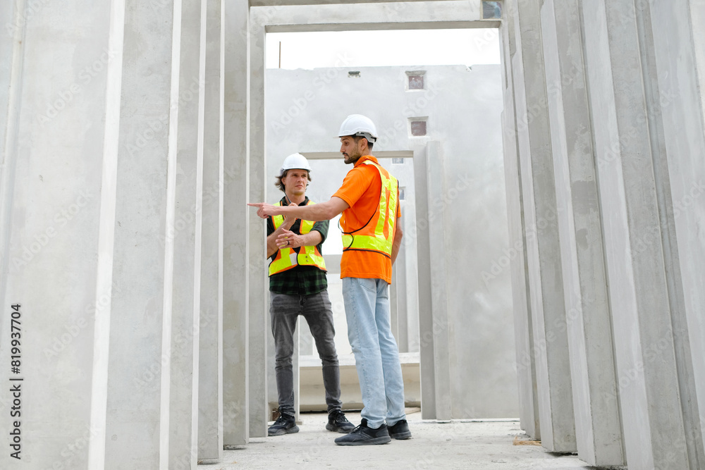 Engineer with concrete wall of prefabricated building.