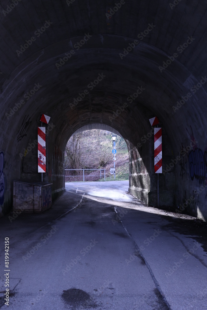 Tunnel with a red and white striped sign on the left side