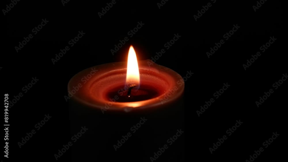 Black candle burning on black background. Copy space for text.