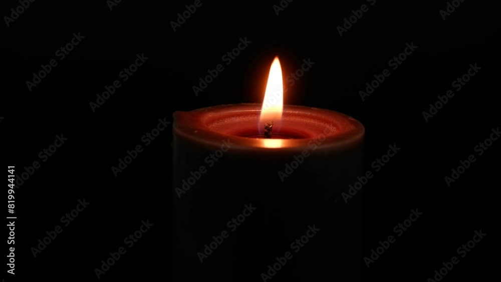 Black candle burning on black background. Copy space for text. Black candle burning on black background. Copy space for text.