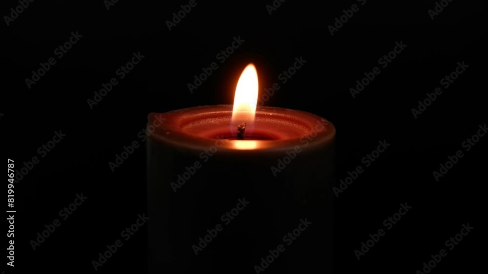 Black candle burning and melting on black background Black candle burning and melting on black background