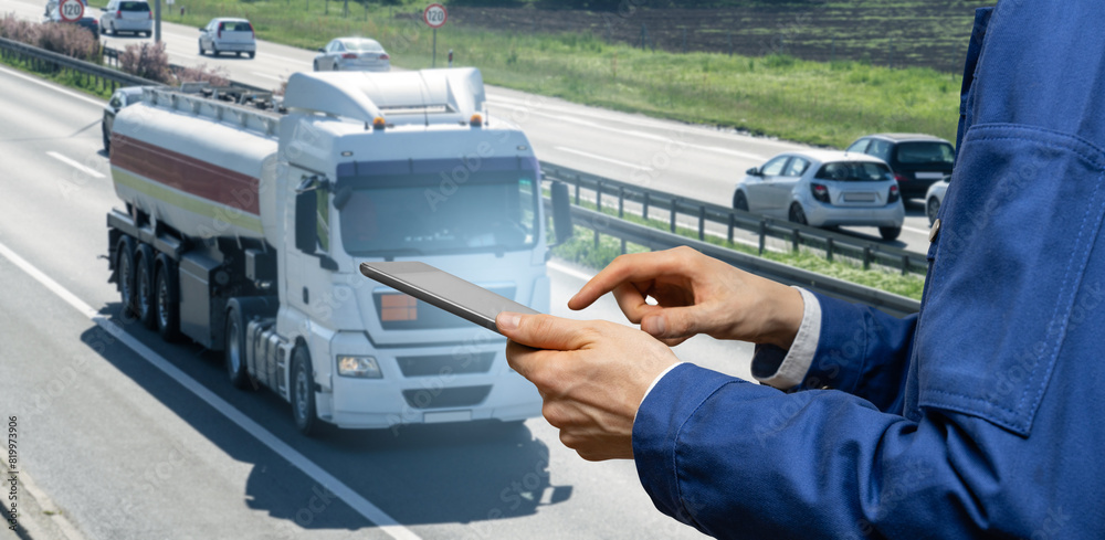 Manager with a digital tablet on the background of truck. Fleet management..