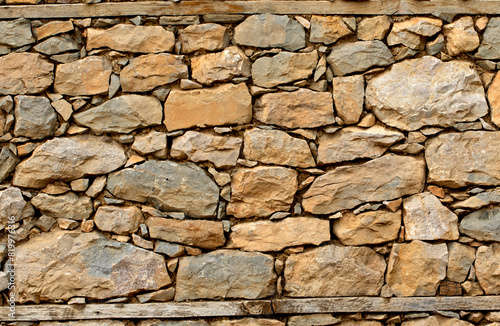 Wall texture of a rustic house  built using random size and colored stone blocks in the Eastern Mediterranean Sea region