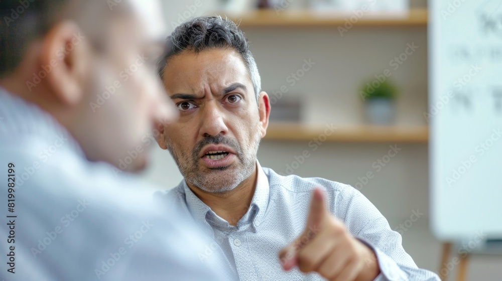 Man in office pointing assertive intense conversation whiteboard blurred background professional attire focused expression serious tone. Man in office pointing assertive intense conversation whiteboard blurred background professional attire focused expression serious tone.