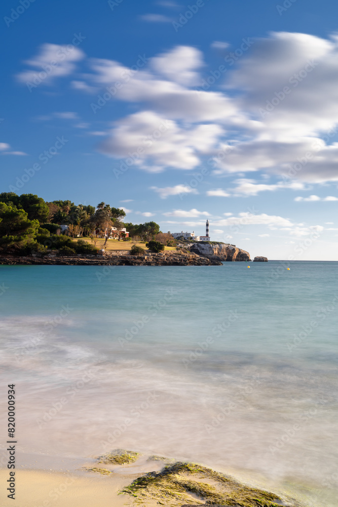 view of the Arenal dets Ases beach and the Portocolom Lighthouse in the background