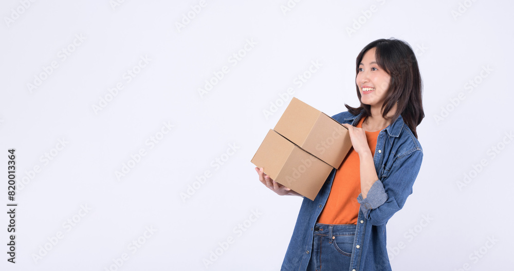 young asian woman wearing orange t-shirt and denim shirt holding parcel box isolated on white studio background, Delivery courier and shipping service concept. young asian woman wearing orange t-shirt and denim shirt holding parcel box isolated on white studio background, Delivery courier and shipping service concept.