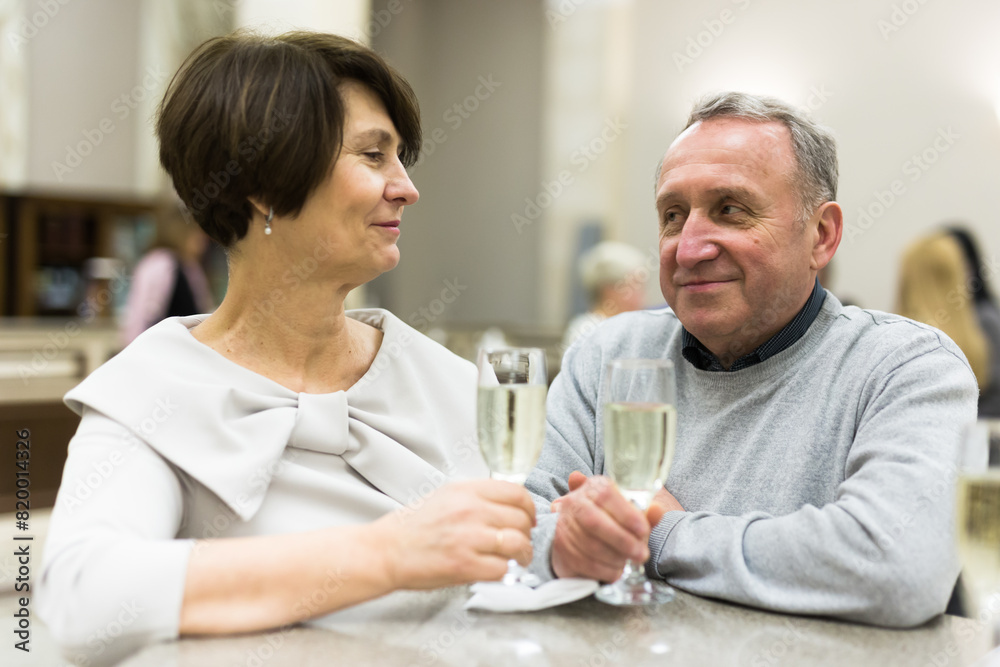 Mature man and woman drinking champagne in theater lobby Mature man and woman drinking champagne in theater lobby