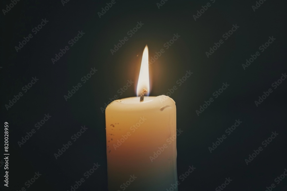 White Candle Burning in the Dark, Isolated on Black Background, Symbolizing Memorial Day Remembrance. White Candle Burning in the Dark, Isolated on Black Background, Symbolizing Memorial Day Remembrance.