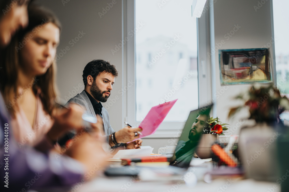 Fototapeta premium In a well-lit office, business professionals are engaged in a strategic meeting, brainstorming ideas and discussing project solutions.
