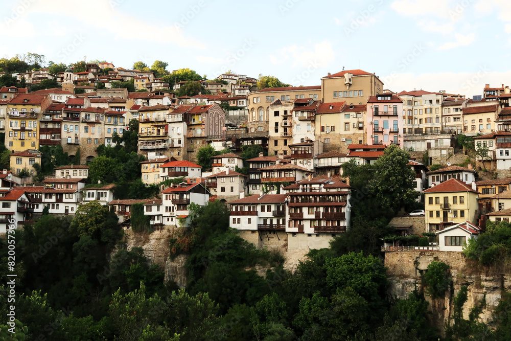 Obraz premium Picturesque view onto one of the neighborhoods of the old town of Veliko Tarnovo, rising above a dense forest, Veliko Tarnovo, Bulgaria