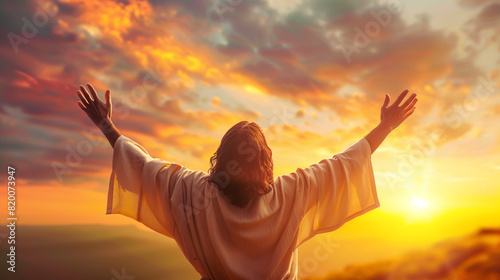 Rear back view of Jesus Christ raised hands and praying to god with a sunrise sky background