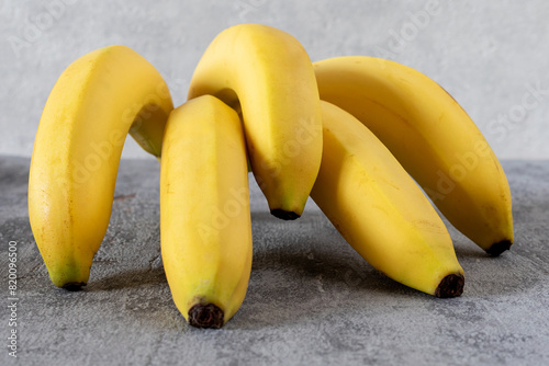 A bunch of bananas lying on a gray surface. 