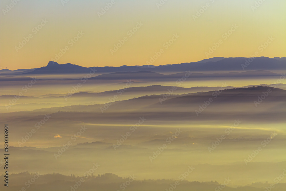 Obraz premium Enchanting Misty Mountain Sunrise with Layered Fog