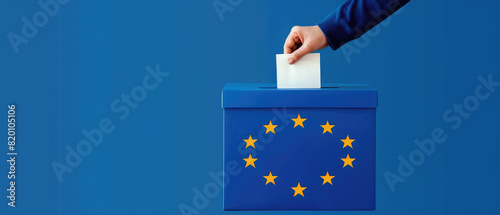 Voting for the European Union election with a hand placing a ballot paper into a ballot box on a solid blue background. This image captures the act of voting and civic participation.