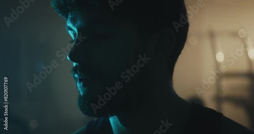 Close-Up Portrait of a Tired Athletic Man in a Moody Gym Atmosphere After Intense Workout