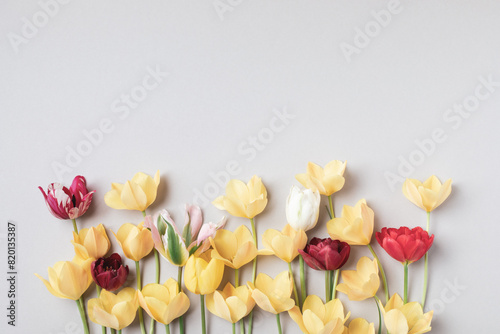 Beautiful aesthetic tulip flowers on neutral beige background top view. Floral border for greeting card. #820135387