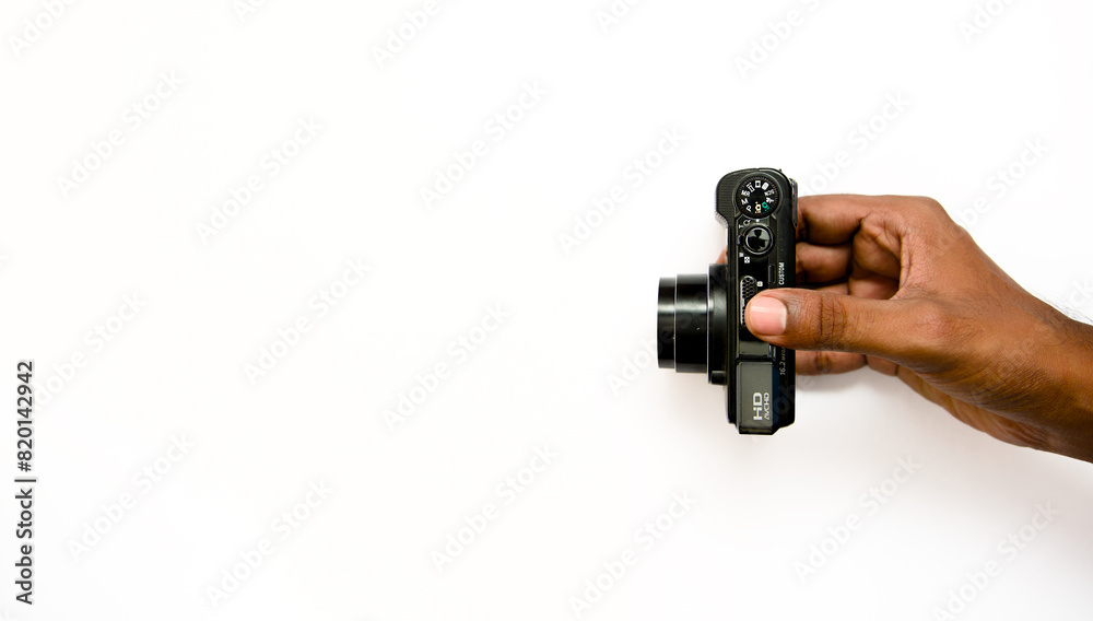 Hand holding a camera on a white background with space for text Hand holding a camera on a white background with space for text