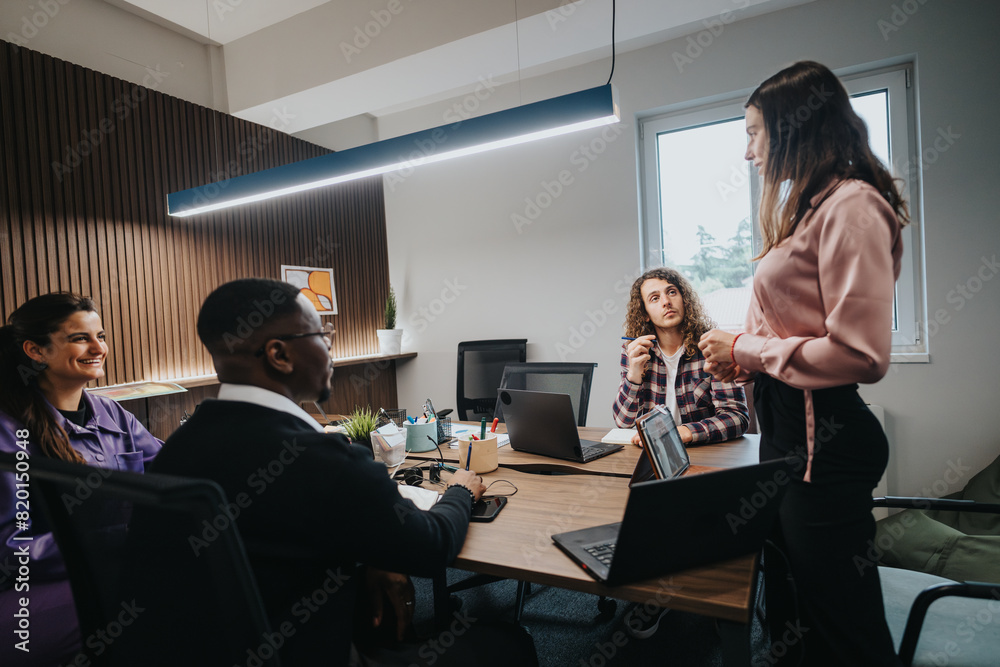 Four professionals collaborating in a modern office environment, discussing project details and sharing ideas for teamwork enhancement. Four professionals collaborating in a modern office environment, discussing project details and sharing ideas for teamwork enhancement.