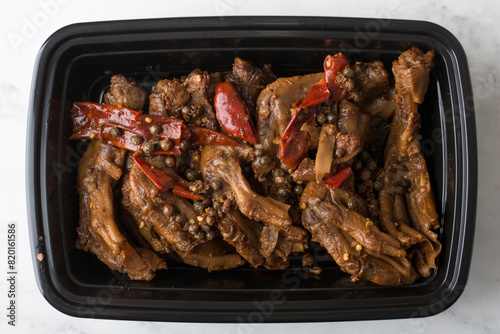 Chinese take out food spicy duck feet in a container