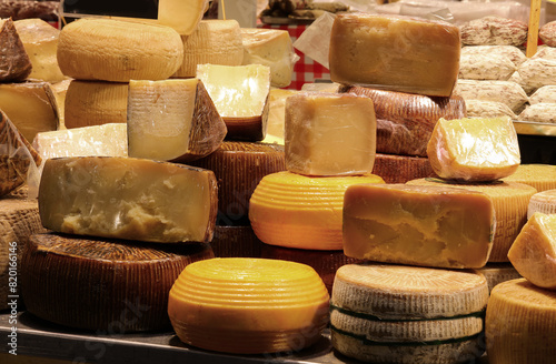 Cheese counter with aged cheeses for sale in wheels or pieces