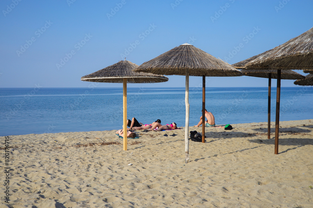 Sandy beach with straw umbrellas on the Olympic Riviera, Nei Pori, Pieria - Greece