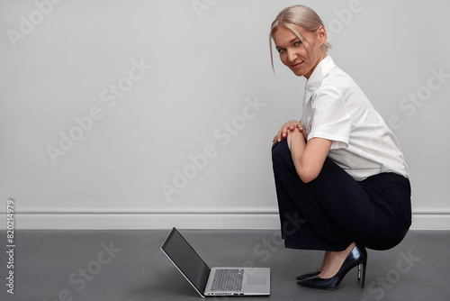 young beautiful blonde freelance or copywriter woman with laptop on the floor