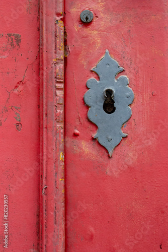 Detalhe de porta vermelha com fechadura de ferro antiga photo
