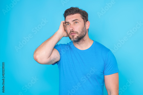 Handsome man standing over yellow background with hand on chin thinking about question. Pensive expression. Thoughtful face. Doubt concept. Thinking question, thoughtful about confusing idea.