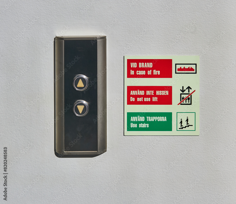 elevator buttons with a sign written in Swedish and English warning that in case of fire do not take the elevator but go down the stairs elevator buttons with a sign written in Swedish and English warning that in case of fire do not take the elevator but go down the stairs
