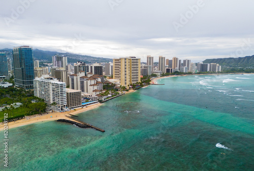 Aerial shot of the hotels of Waikiki Beach in Honolulu under overcast skies with rain on the mountains